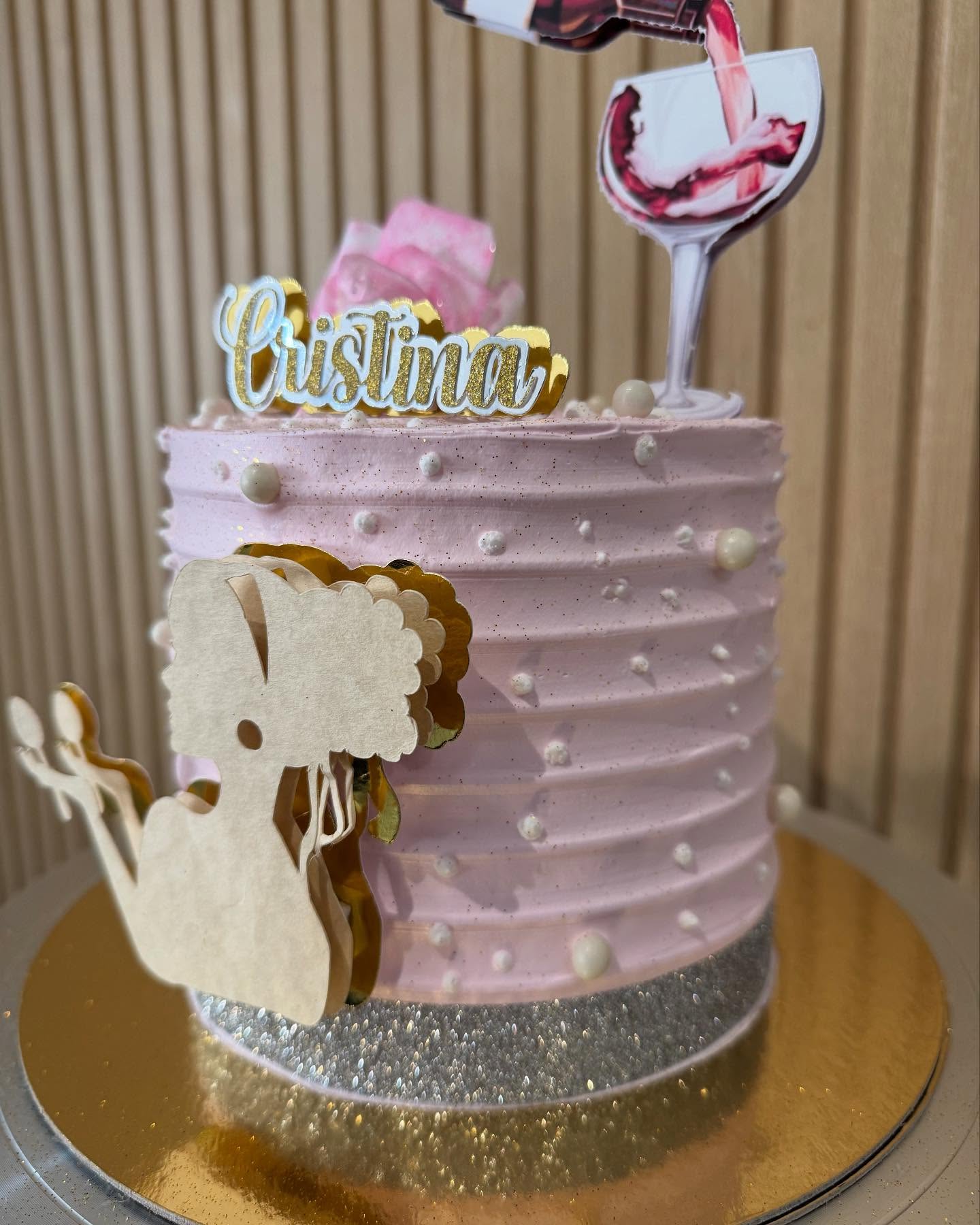 Pastel rosa de cumpleaños con flores, perlas y el nombre Cristina